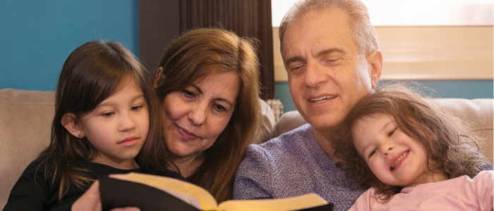 Two older people read with two children