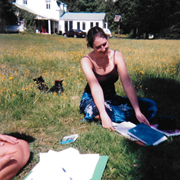 une femme sur une pelouse avec des livres devant elle